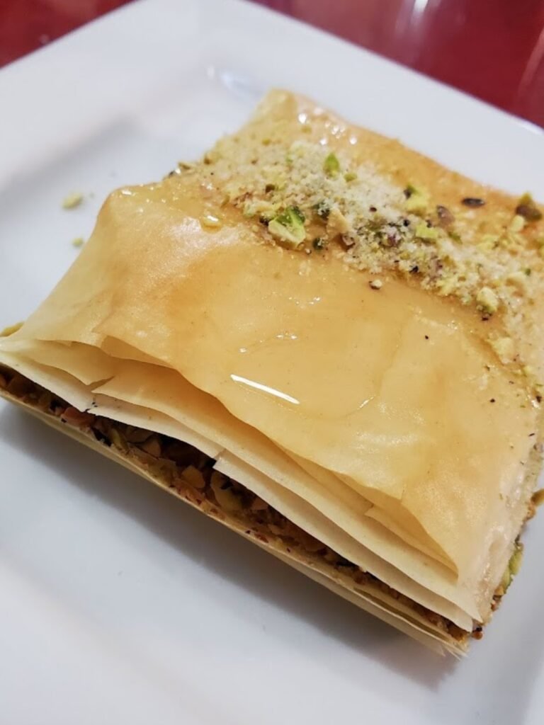Close-up of homemade Lebanese baklava topped with crushed pistachios and honey syrup at That Lebanese Place.