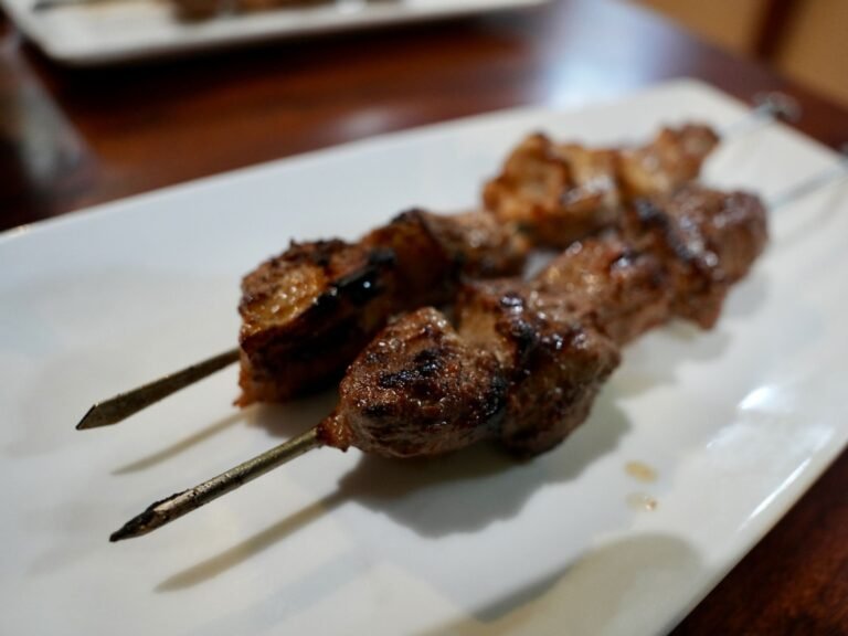 Two perfectly grilled Lebanese meat skewers served on a white plate at That Lebanese Place.