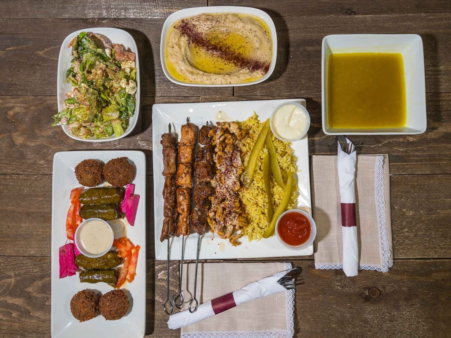 The Meal for Two platter at That Lebanese Place featuring grilled kebabs, rice, hummus, falafel, salad, soup, and stuffed grape leaves — a Lebanese sampler made to share.
