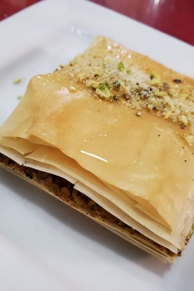 Close-up of homemade Lebanese baklava topped with crushed pistachios and honey syrup at That Lebanese Place.