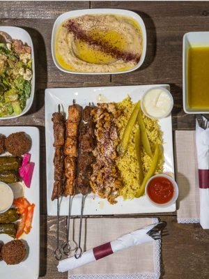 The Meal for Two platter at That Lebanese Place featuring grilled kebabs, rice, hummus, falafel, salad, soup, and stuffed grape leaves — a Lebanese sampler made to share.