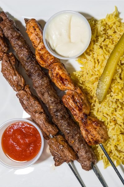 Mixed Grill Kabab plate from That Lebanese Place featuring chicken, beef, and kafta skewers served with basmati rice, homemade pickles, garlic sauce, and spicy red sauce.